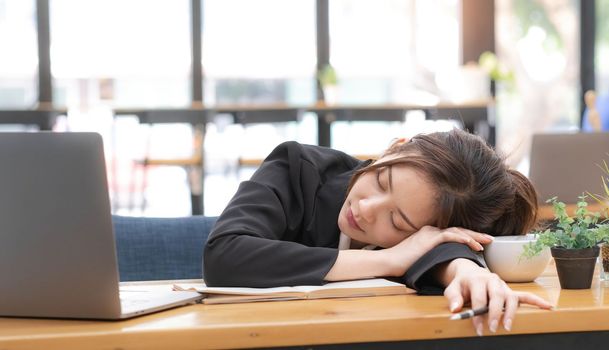 Sad Young woman employee having problems about her debts and financials. Frustrated Asian Beautiful businesswoman feeling depression, exhausted, tired, lazy during working at the office...