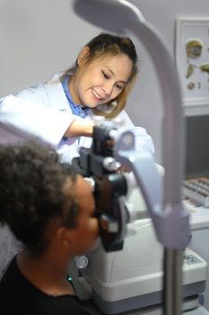 Young woman ophthalmologist checking eye vision of patient for spectacles glasses. Eye health check concept.