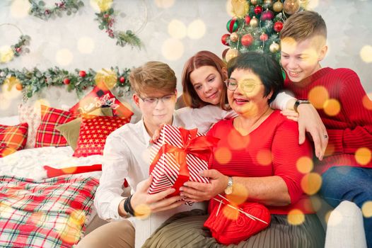 Mother with three children unpacks a christmas gift. Christmas wonder. christmas holiday