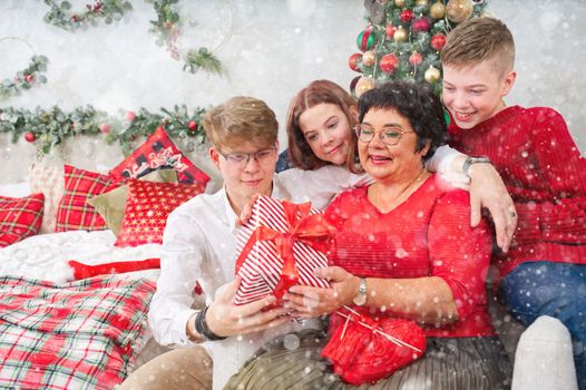 Mother with three children unpacks a christmas gift. Christmas wonder. christmas holiday