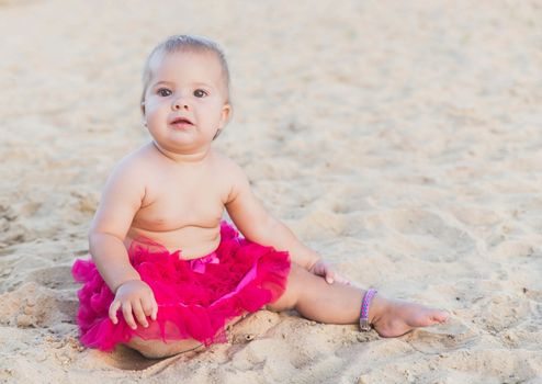 babe in pink skirt sunbathing on the beach.