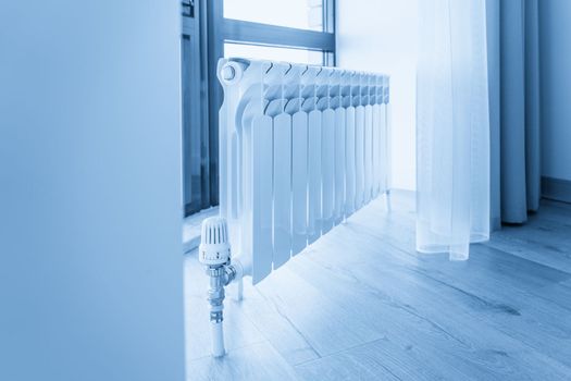 White big radiator near window in a modern room