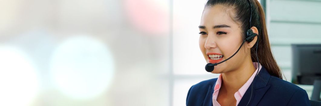 Business people wearing headset working in office in widen view to support remote customer or colleague. Call center, telemarketing, customer support agent provide service on telephone video call.