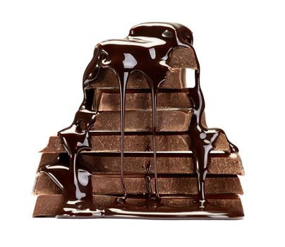 close up of chocolate pieces stack and chocolate syrup on white background