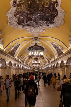 April 1, 2022, Moscow Russia. A beautiful metro station with a beautiful chandelier and people.. City life, a lot of people use public transport during rush hour.