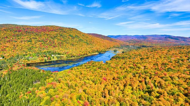 Image of Lake tucked into colorful peak fall mountains in New York