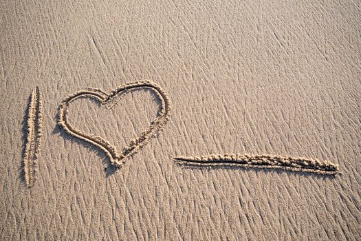 I love Heart message handwritten in clean sand with copy space for text on the beach.