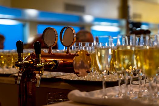 many beautiful glasses of champagne during a party on the table in the bar. close-up. glasses with cool champagne or white wine stand in rows on the bar counter, soft focus.