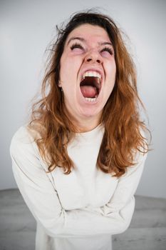 Close-up portrait of insane woman in straitjacket on white background