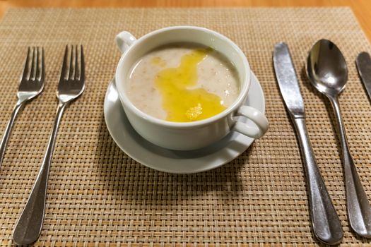 a white bowl with hot herculean porridge on the table. breakfast, morning tea, snack