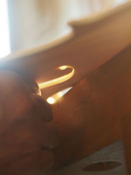 violinmaker cutting and sawing golden period cremonese violin model fholes with a blade with precision