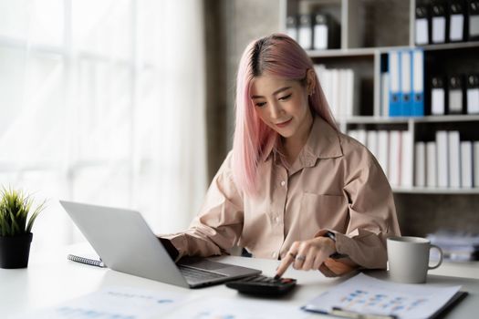 Asian Business woman working to analyze technical price graph and indicator with business team talking by cell phone. account or saving money or insurance concept.