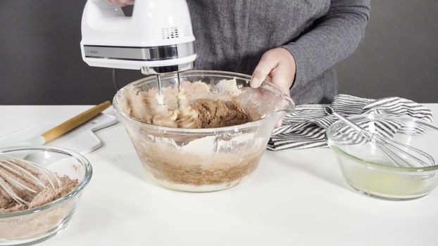 Step by step. Mixing ingredients in a glass mixing bowl to bake chocolate cookies.
