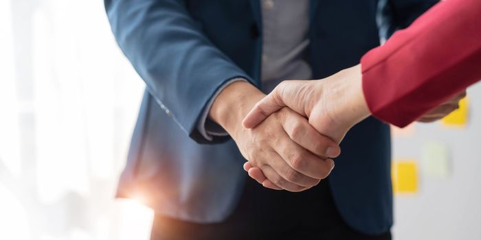Business handshake for teamwork of business merger and acquisition,successful negotiate,hand shake,two businessman shake hand with partner to celebration partnership and business deal concept...