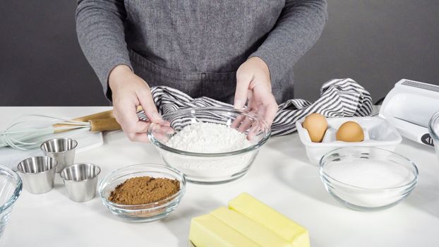 Step by step. Mixing ingredients in a glass mixing bowl to bake chocolate cookies.