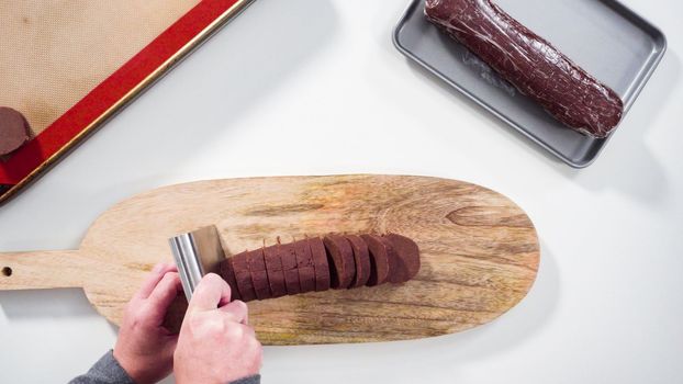 Step by step. Flat lay. Cutting chocolate cookie dough on a wood cutting board.