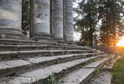 crumbleded steps and columns at the entrance to the temple at sunset.