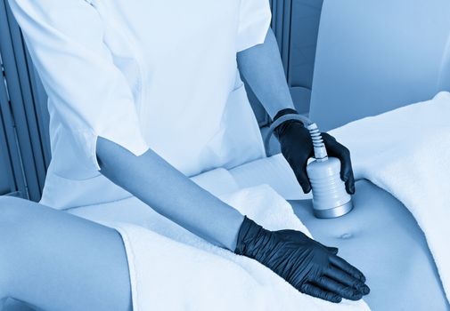 Ultrasound cavitation body contouring treatment. Woman getting anti-cellulite and anti-fat therapy on her leg in beauty salon.