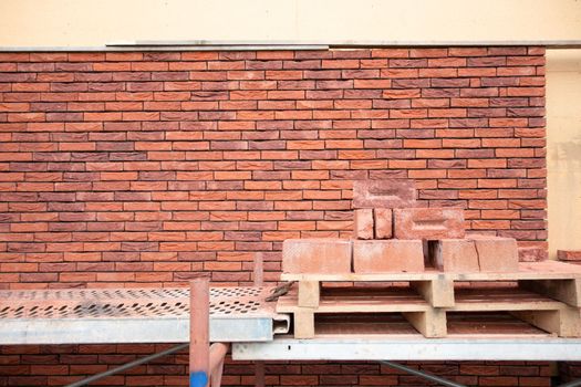 a new House is being built, the beginning of brickwork with red bricks, building materials, a pattern of stones, a natural background. High quality photo