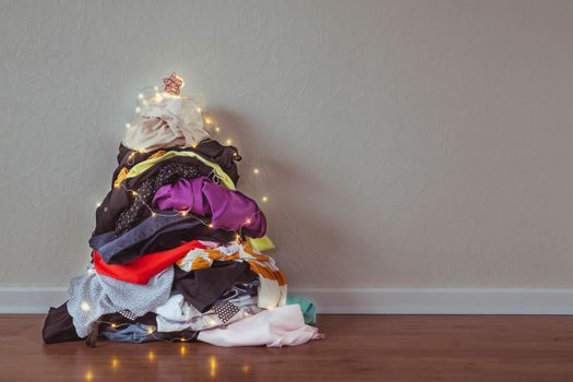 A pile of clothes in the shape of a Christmas tree.