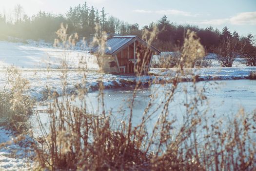 Small fishing hut on the lake in winter Denmark.