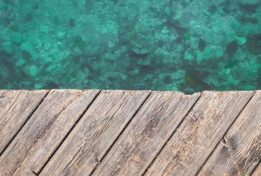 Marine background. Old wooden pier and turquoise water.