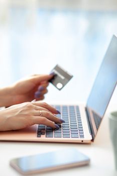 Purchases via the Internet and payment for services buy credit card. Hands type text and enter data on the laptop keyboard. An office worker checks his email while sitting at his desk