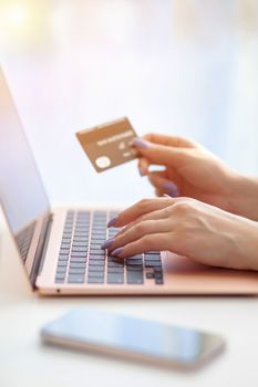 Purchases via the Internet and payment for services buy credit card. Hands type text and enter data on the laptop keyboard. An office worker checks his email while sitting at his desk