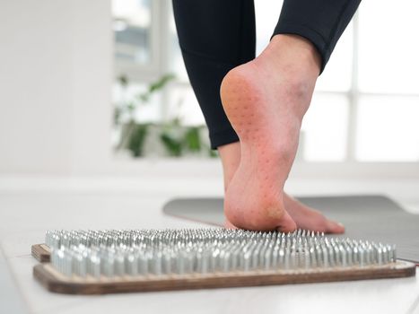 A woman comes down from the sadhu boards. Close-up of feet with prints after nails