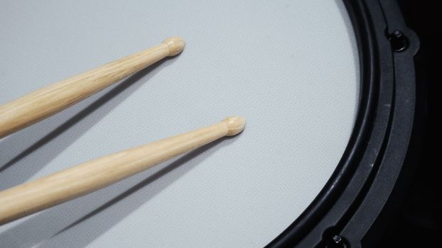Close-up images of drumsticks on electronic drum snare pad which is main music instrumental to make beat for musician or songwritter and equipment for recording in sound design studio by drummer