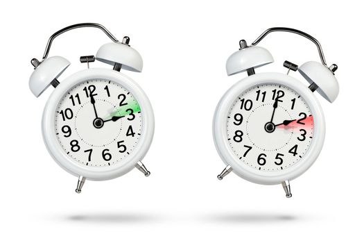 Change time. Winter and summer time concept isolated on white background. Change the time in spring and autumn, a white alarm clock indicates a change in time one hour ago, one hour ahead