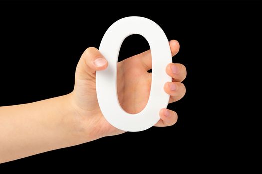 Zero in hand. The number zero is clasped in a hand isolated on a black background. Number zero white in a child's hand on a black background