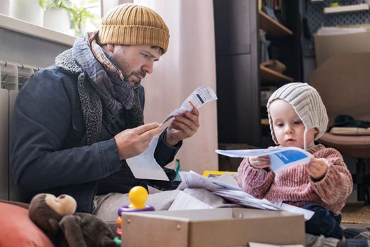 Man wearing warm clothing feeling cold checking central heating battery. Energy crisis in Europe