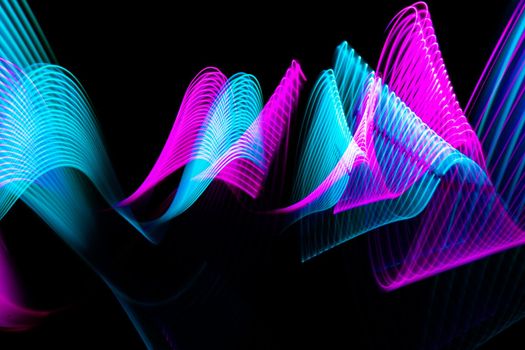 Modern light painting waves design. Technology neon blue and pink lines on black background. High quality photo