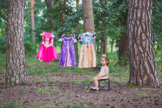 Charming baby hung out princess costumes to dry.