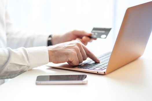 Purchases via the Internet and payment for services buy credit card. Hands type text and enter data on the laptop keyboard. An office worker checks his email while sitting at his desk