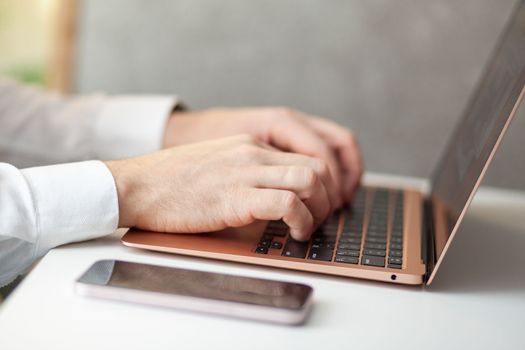 Purchases via the Internet and payment for services buy credit card. Hands type text and enter data on the laptop keyboard. An office worker checks his email while sitting at his desk