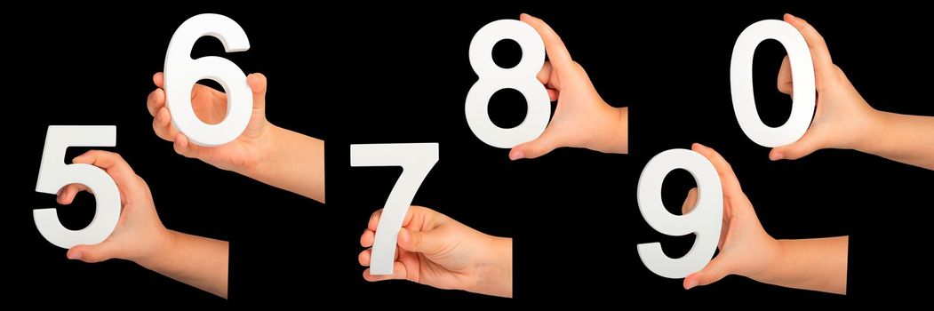 Children's hands hold numbers. A set of white numbers in hands on a black isolated background. Zero, five, six, seven, eight, nine