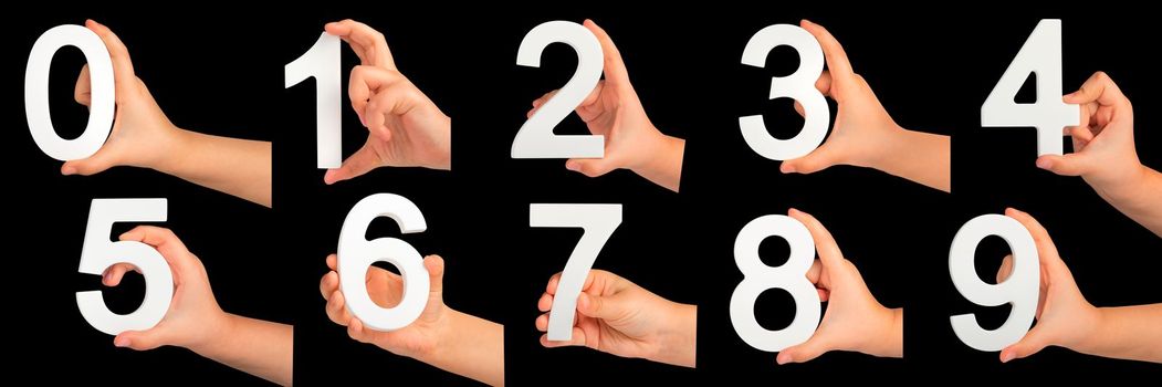 Children's hands hold numbers. A set of white numbers in hands on a black isolated background. Zero, one, two, three, four, five, six, seven, eight, nine