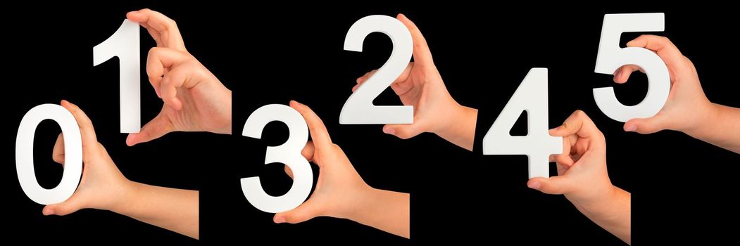 Children's hands hold numbers. A set of white numbers in hands on a black isolated background. Zero, one, two, three, four, five