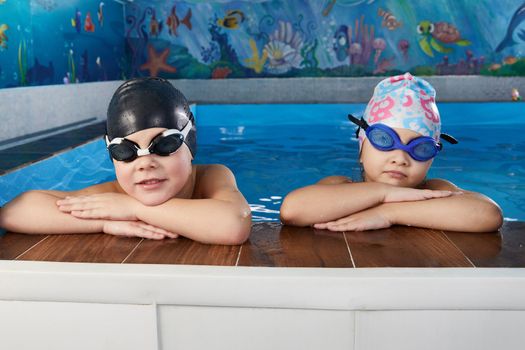 Kids taking a break during swimming class in the indoor pool