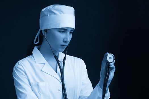 Young female doctor holding stethoscope hanging on her neck