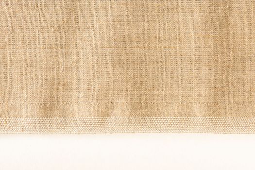 Texture of linen fabric. Natural linen fabric with a finished edge on a white background