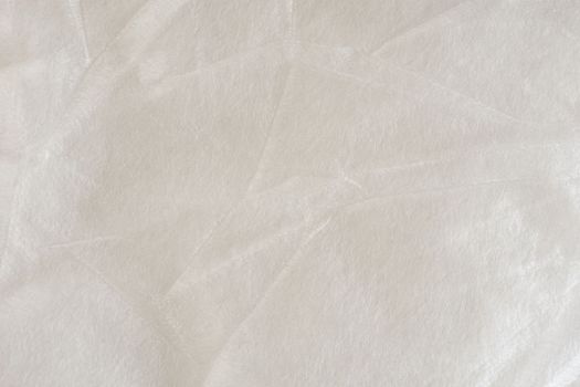 A white synthetic polyester material used as insulation in clothing or as packaging material. Texture close-up