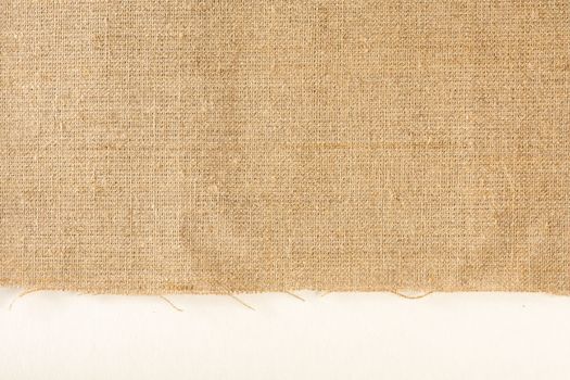 Texture of linen fabric. Natural linen fabric with a raw edge on a white background