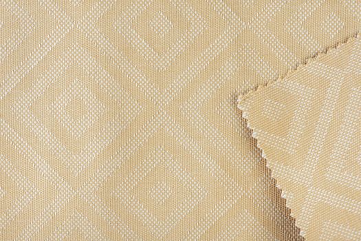 Texture of fabric for furniture upholstery in beige color with rectangular patterns or rhombuses. Texture of wear-resistant fabric for furniture production, close-up, top view