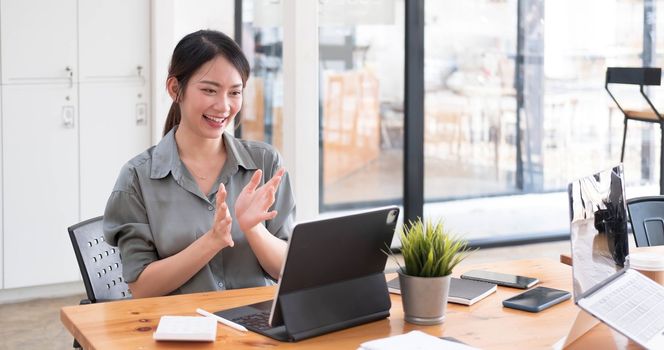 Pretty Asian businesswoman sitting on a laptop And the work came out successfully and the goal was achieved, happy and satisfied with her...