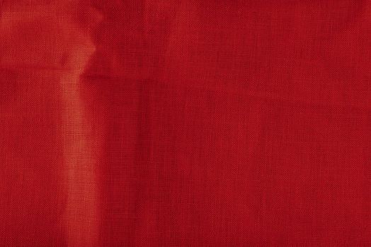 Red linen fabric. Texture of crumpled linen fabric in folds close-up