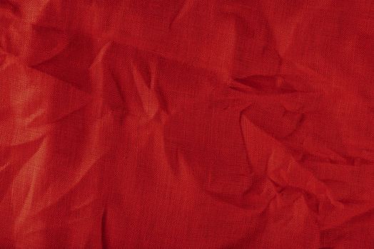 Red linen fabric. Texture of crumpled linen fabric in folds close-up