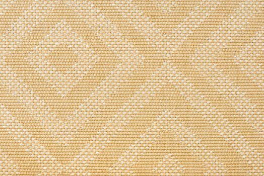 Texture of fabric for furniture upholstery in beige color with rectangular patterns or rhombuses. Texture of wear-resistant fabric for furniture production, close-up, top view